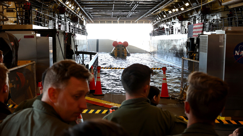 U.S. Navy pilots gather after NASA's Orion Capsule was brought into the well deck of the U.S.S. Portland after it splashed down following a successful uncrewed Artemis I Moon Mission, on December 11, 2022 in the Pacific Ocean off the coast of Baja California, Mexico.