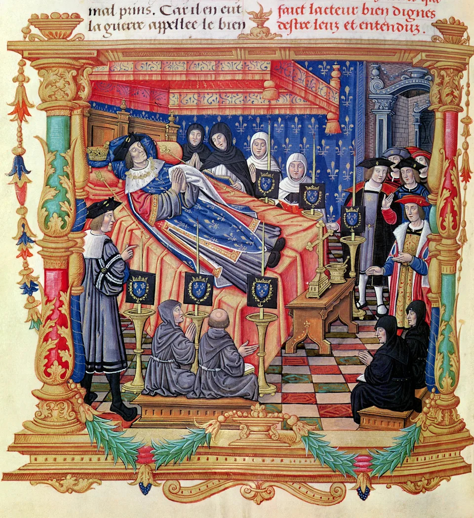 Medieval illustration of a king on his deathbed, surrounded by clergy and attendants in a richly decorated room, with a Latin script above