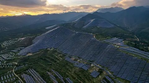 Getty Images Under a dramatic sky rows of blue solar photovoltaic panels neatly arranged at the leading Photovoltaic Technology base in Yuncheng City, Shanxi Province, China.